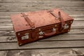 Vintage leather suitcase on a wooden deck