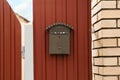 Vintage letter box on red fence near brick wall outdoors Royalty Free Stock Photo