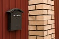 Vintage letter box on red fence near brick wall outdoors Royalty Free Stock Photo