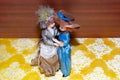 Vintage LGBT lesbians concept. ceramic porcelain dolls in vintage dress. dolls standing on the wooden and yellow background.