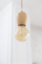 Vintage wooden light bulb hanging on white background. Royalty Free Stock Photo