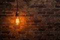 vintage light bulb hanging from a wire against a brick wall Royalty Free Stock Photo