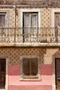 Vintage Lisbon house faÃ§ade front with colorful tiles and pink painted wall. An old vintage iron balcony Royalty Free Stock Photo