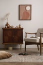 Vintage living room interior with mock up poster frame, wooden sideboard, boucle armchair, books, brown pillow, patterned carpet,