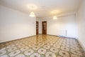 vintage living room with white pvc walls, striking stoneware floors, two sapele wood doors and radiators on the wall Royalty Free Stock Photo