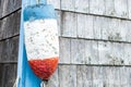 Vintage lobster buoy hanging on the corner of a fishing shack