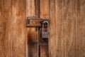 Vintage locked padlock with chain at brown wooden door background Royalty Free Stock Photo