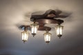 Vintage lustre with decorative lanterns hangs on ceiling