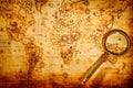 Vintage magnifying glass lies on an ancient world map