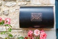 Vintage mailbox against a stone wall with roses around Royalty Free Stock Photo