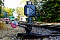 vintage manual railway or railroad switch. steel bar arm and metal weigh. rail yard in background