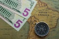 Vintage map of South America with five dolor bills and a compass, close-up