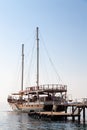 Vintage mast wooden sailing ship for sea tours. Touristic pirate ship in port. Marina in in resort city Kemer, Turkey. Old harbour