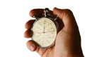 Vintage mechanical wind up stop watch held in left hand with fingers on reset positions, white background