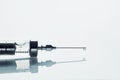 Vintage medical glass syringe with a liquid drop on the needle on white background