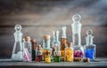 Vintage medications in small bottles on wood desk. Old medical, chemistry and pharmacy history concept background.