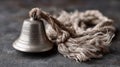 Vintage metal bell with frayed rope on rustic surface Royalty Free Stock Photo