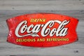 Vintage Metal Coca Cola Sign isolated on wooden background