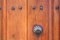 Vintage metal handle on old brown wooden door with metal rivets front view close up Royalty Free Stock Photo