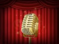 Vintage metal microphone. Red silk curtain backdrop. Retro mic on empty theatre stage. Royalty Free Stock Photo