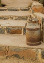 Vintage metal milk can isolated on stone steps Royalty Free Stock Photo