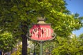 Vintage metro sign surrounded by trees in Paris during a sunny day Royalty Free Stock Photo