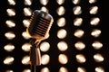 Vintage mic against dark sparkling bokeh backdrop. Royalty Free Stock Photo