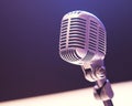 A vintage microphone, featuring chrome and silver, is positioned in soft, diffused light Royalty Free Stock Photo
