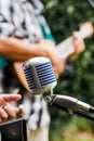 Vintage microphone with latin musician playing a guitar at the background at the street in Mexico Royalty Free Stock Photo