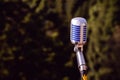 Vintage microphone, metallic retro style with forest or nature in the background, live show concept