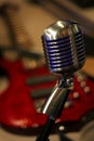 Vintage Microphone with Red Electric Guitar in Background