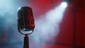Vintage microphone stands bathed in red stage lights creating a dramatic atmosphere for performance Royalty Free Stock Photo