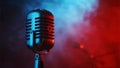 Vintage microphone stands bathed in red stage lights creating a dramatic atmosphere for performance Royalty Free Stock Photo