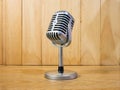 The vintage microphone on wood table for podcast or media concept