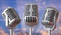 Vintage microphones trio with sun rays sky Royalty Free Stock Photo