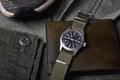 Vintage military watch and leather wallet on army green background, Classic timepiece