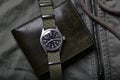 Vintage military watch and leather wallet on army green background, Classic timepiece mechanical wristwatch