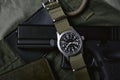 Vintage military watch wallet and pistol on army green background, Classic timepiece mechanical wristwatch