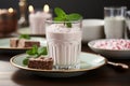 Vintage milk glass strawberry milkshake with fresh strawberries and mint leaves on wooden background