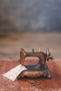 Vintage mini sewing machine with scissors, buttons and fabric on rustic background Royalty Free Stock Photo