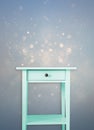 Vintage mint wooden chest drawer near vintage dreamy blue glitter background