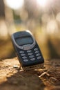 Vintage mobile phone resting outdoors in warm sunlight Royalty Free Stock Photo