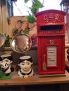 Vintage model of an old red post box and character mugs.