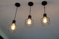 Vintage, modern hanging 3 light bulb over gray background. Interior design. Royalty Free Stock Photo