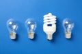 Vintage and modern lightbulbs on blue background, flat lay Royalty Free Stock Photo