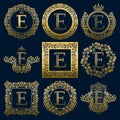 Vintage monograms set of E letter. Golden heraldic logos in wreaths, round and square frames Royalty Free Stock Photo