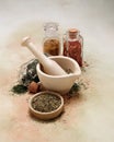 Old mortar and pestle with spices and herbs on softly colored canvas Royalty Free Stock Photo