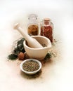 Mortar and pestle with spices and herbs on white canvas table cloth Royalty Free Stock Photo