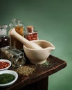 Vintage mortar and pestle with spices and herbs on wooden table Royalty Free Stock Photo