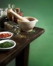 Mortar and pestle with herbs and spices on wood table Royalty Free Stock Photo